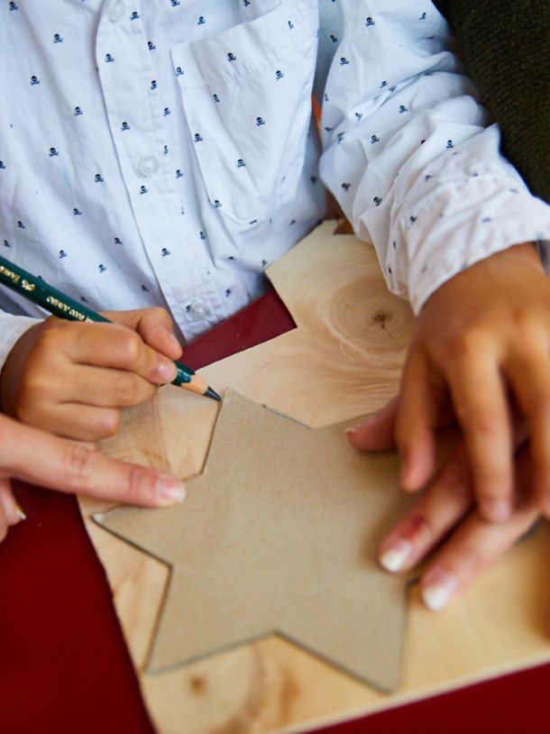 Ein Ergotherapeut hilft einem Kind beim Zeichnen einer Form